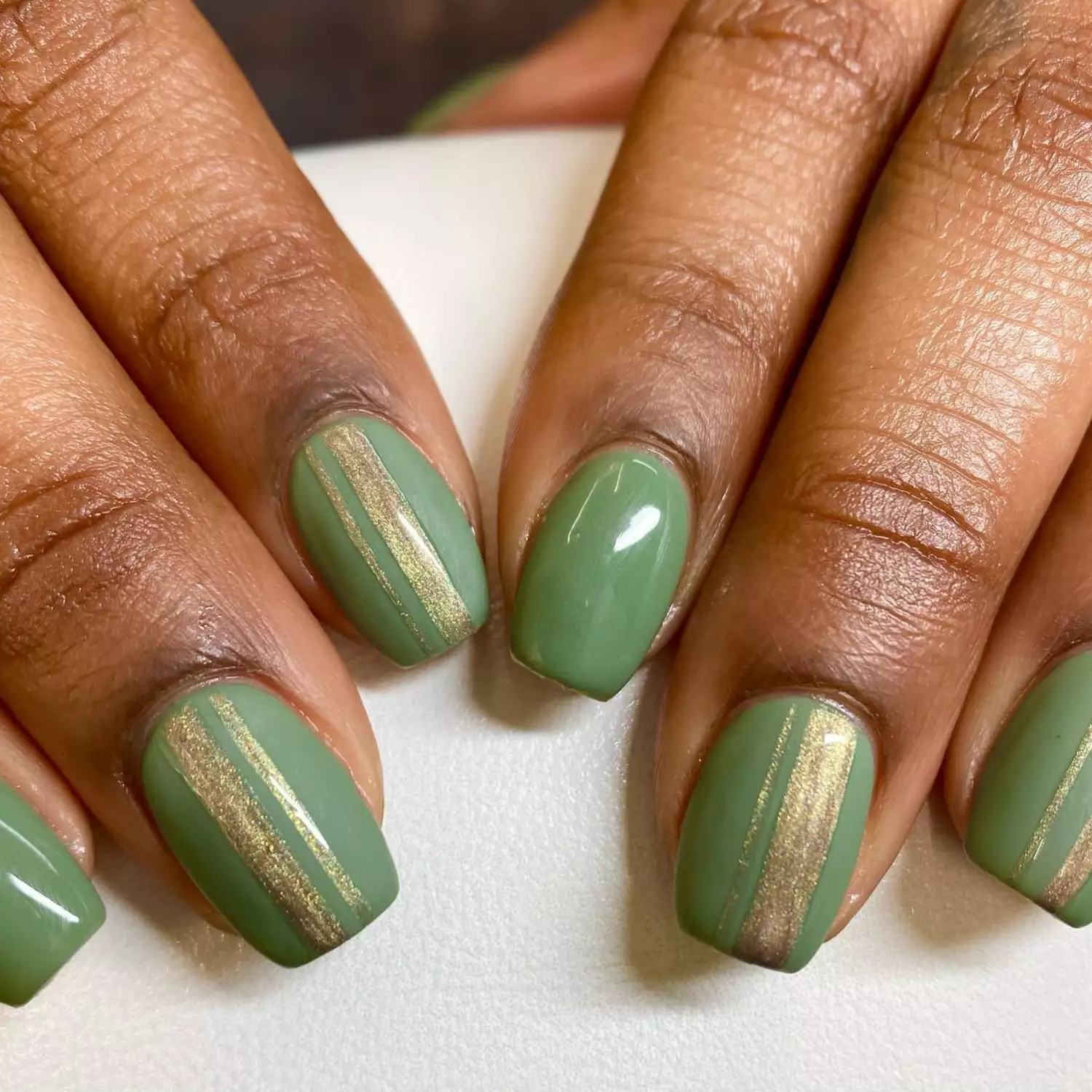 green nails with gold detailing manicure